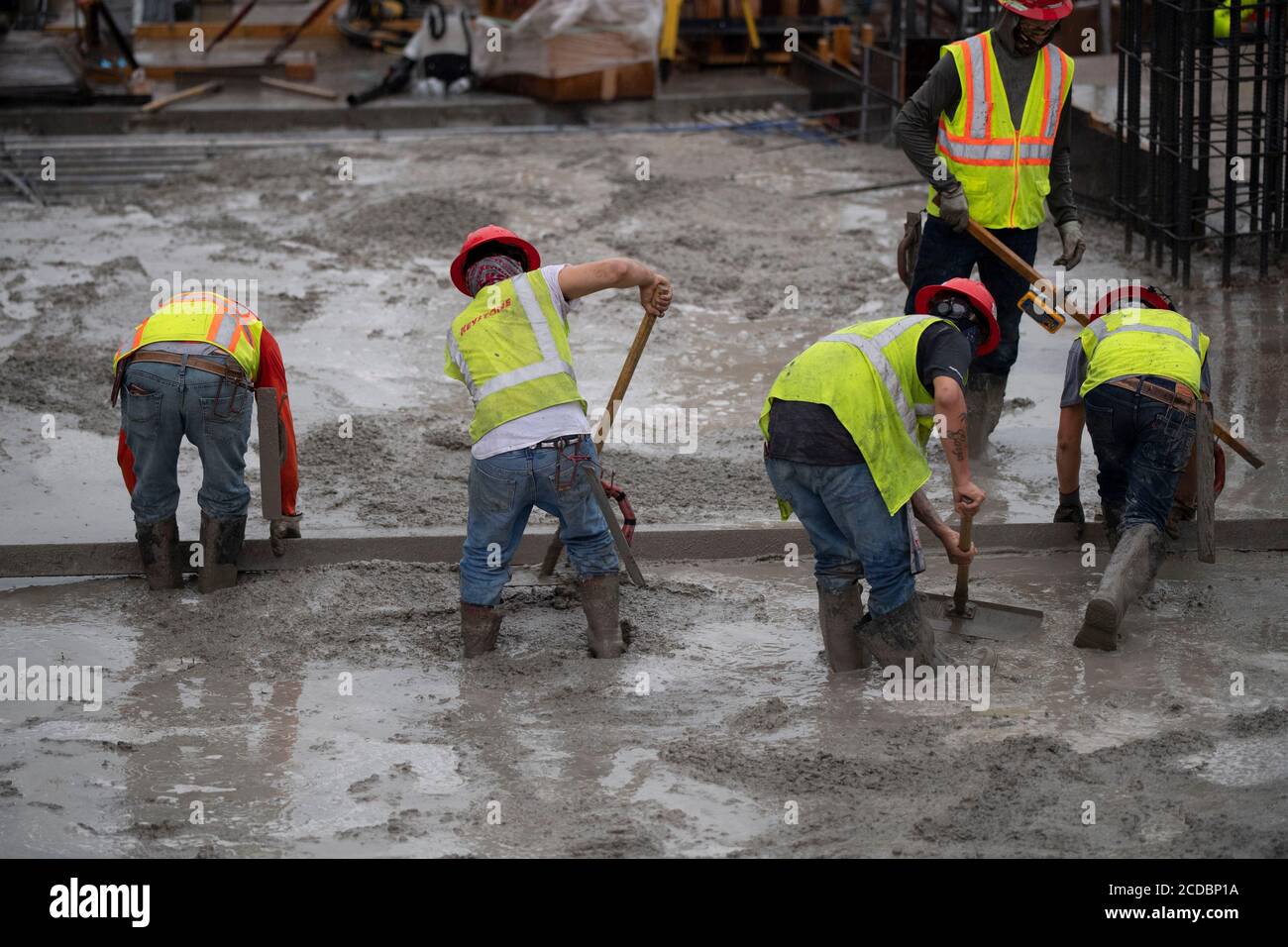 Austin, Texas USA 22 agosto 2020: Esperti equipaggi di calcestruzzo conducono un versamento notturno e la prima mattina levigando e modellando sui piani superiori di un alto garage di parcheggio nel centro di Austin. I grandi progetti di costruzione continuano senza arresto durante gli arresti del coronavirus in Texas. Foto Stock