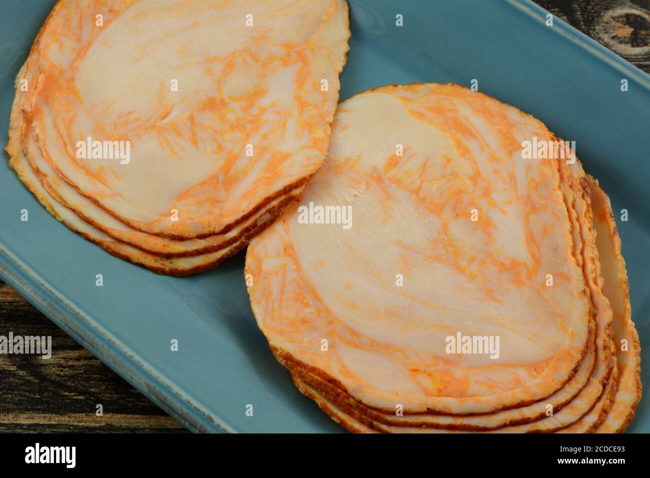 Petto di pollo in stile bufalo a fette fredde su piatto blu Foto Stock