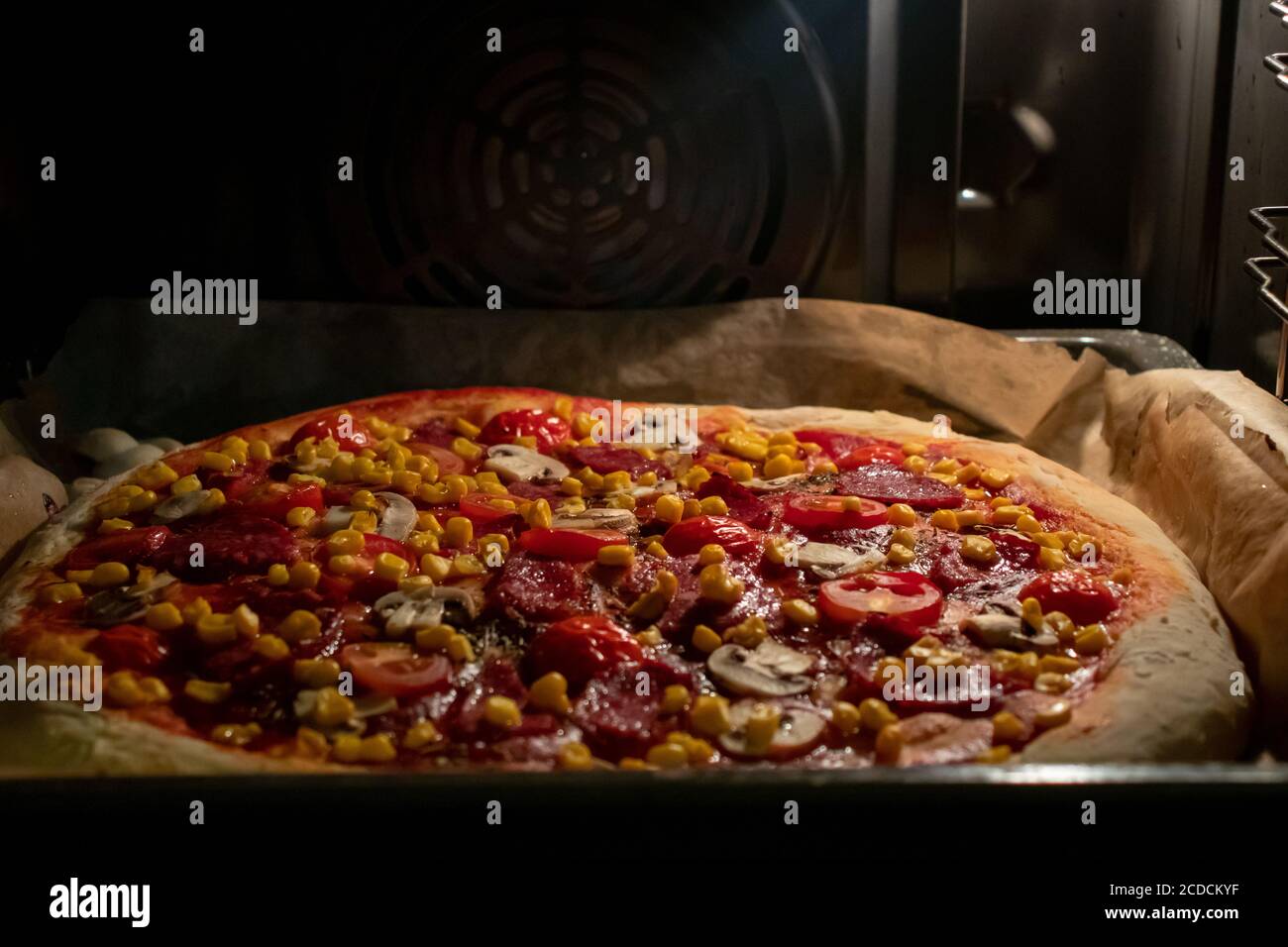 Pizza fatta in casa in forno elettrico su impasto spesso Foto stock - Alamy