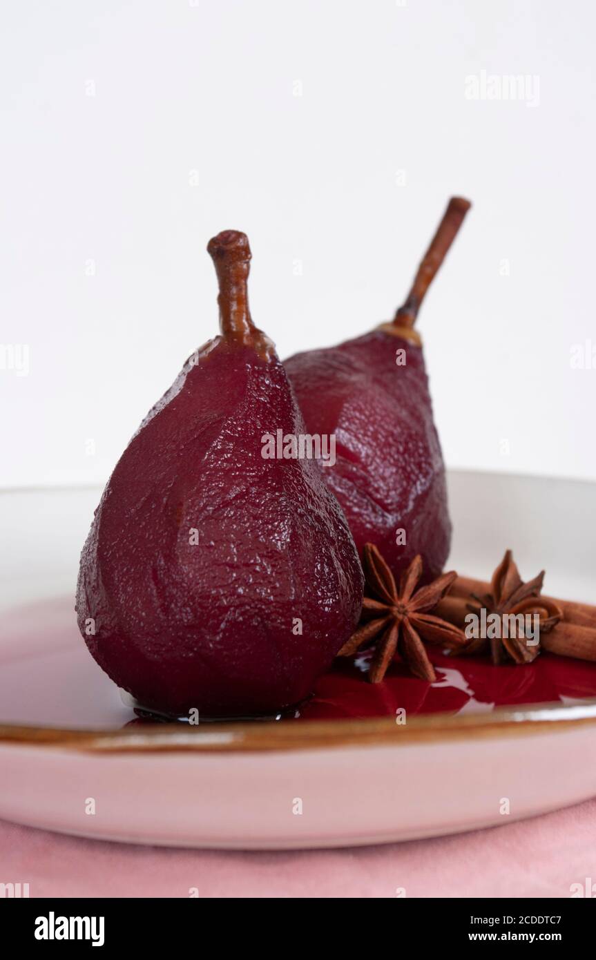 Pere in camicia in vino rosso con cannella. Dessert di frutta, ricetta fatta in casa. Foto Stock
