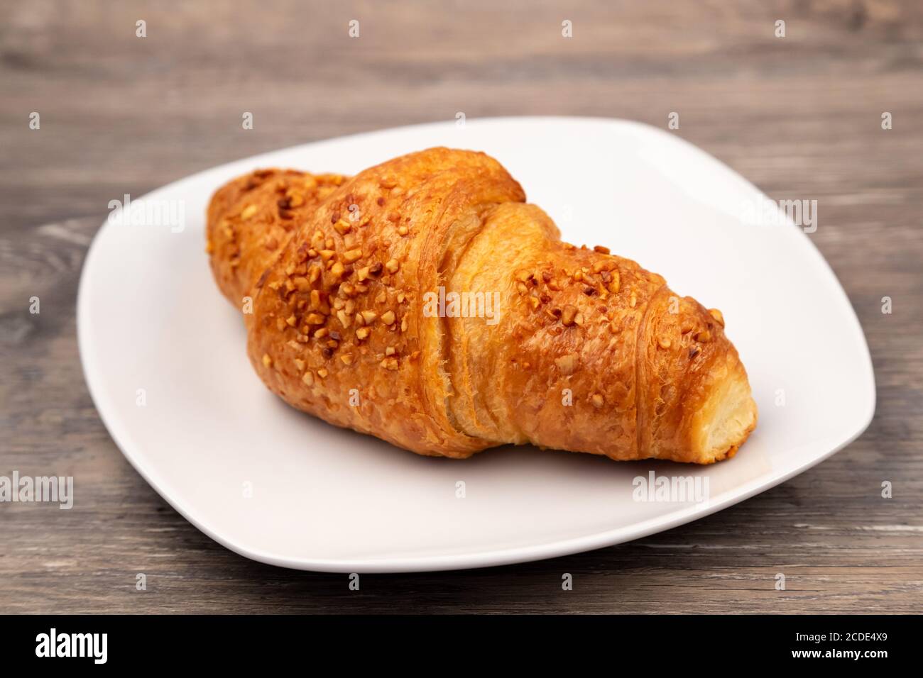 Un delizioso croissant su un piatto Foto Stock