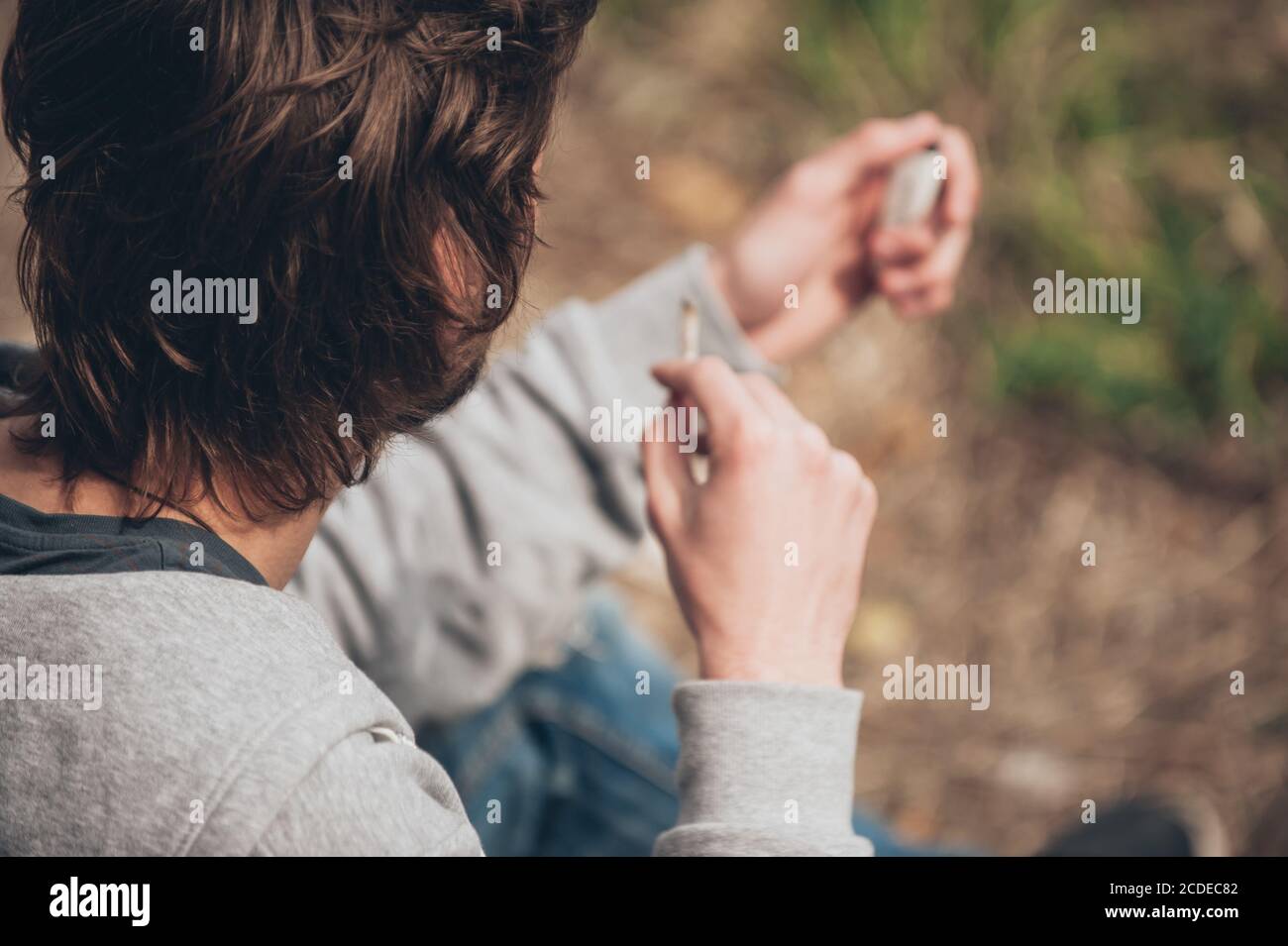 L'uomo illuminazione di un giunto di marijuana o di hashish comune di sigaretta in metropolitana Quartiere ghetto Foto Stock