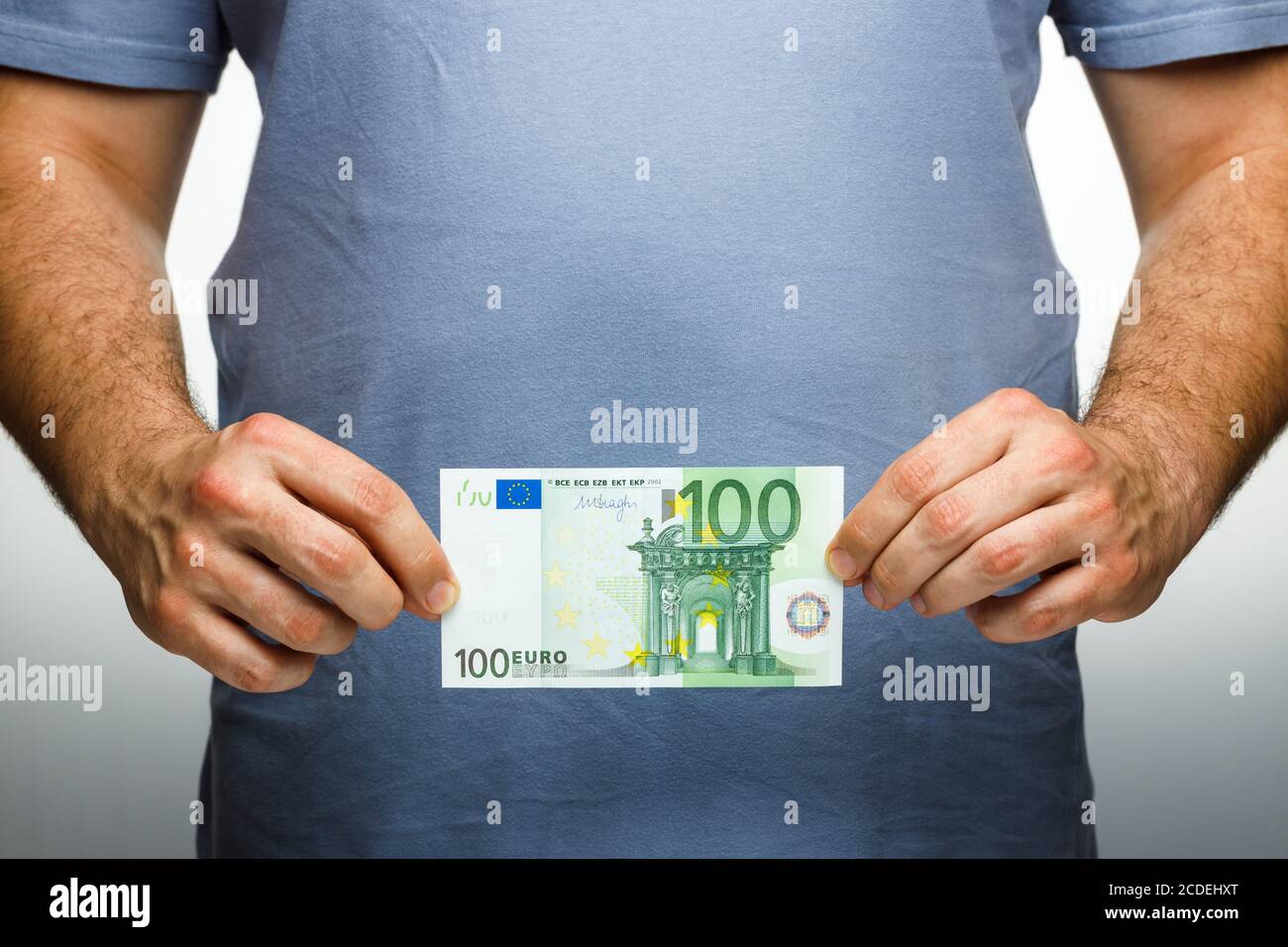 Un uomo tiene un centinaio di euro nelle sue mani. Concetto finanziario e commerciale. Foto Stock