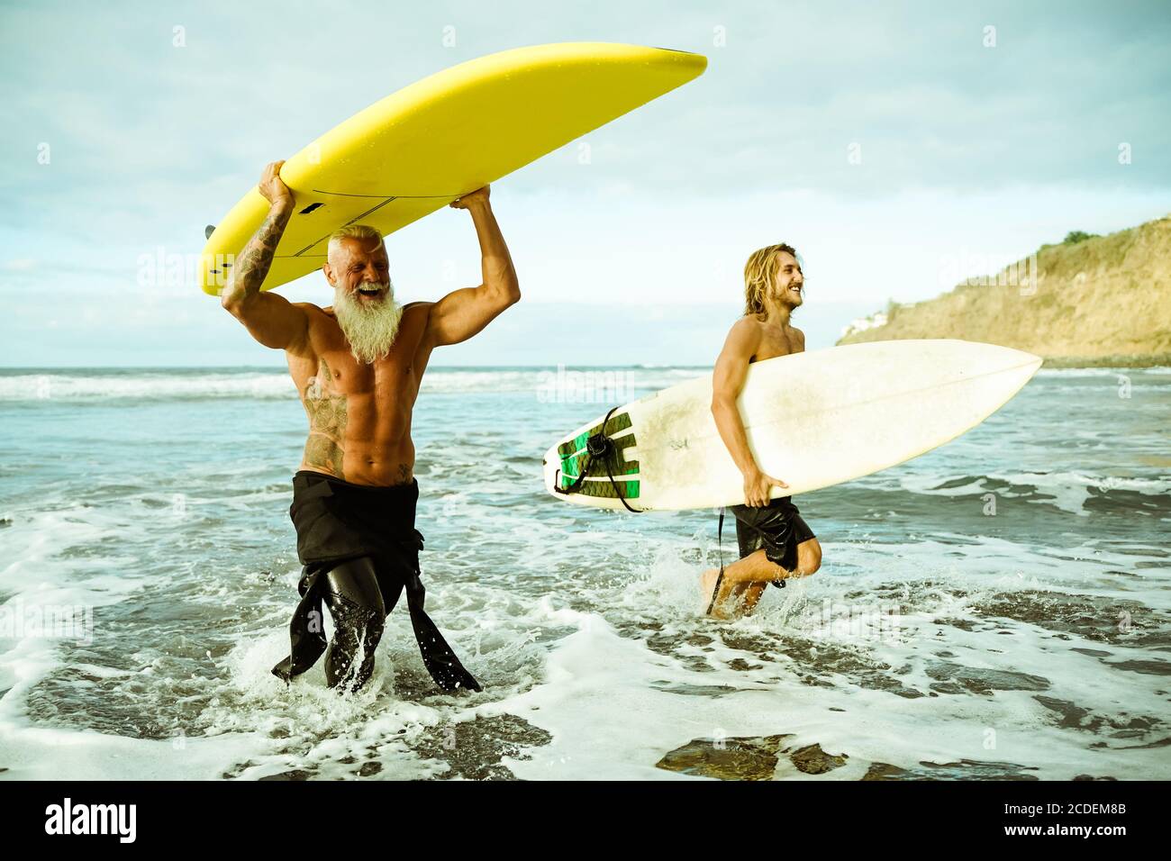 I migliori amici che fanno surf in estate . Gente che esce nell'oceano. Stile di vita sportivo e concetto di sport estremo - immagine Foto Stock