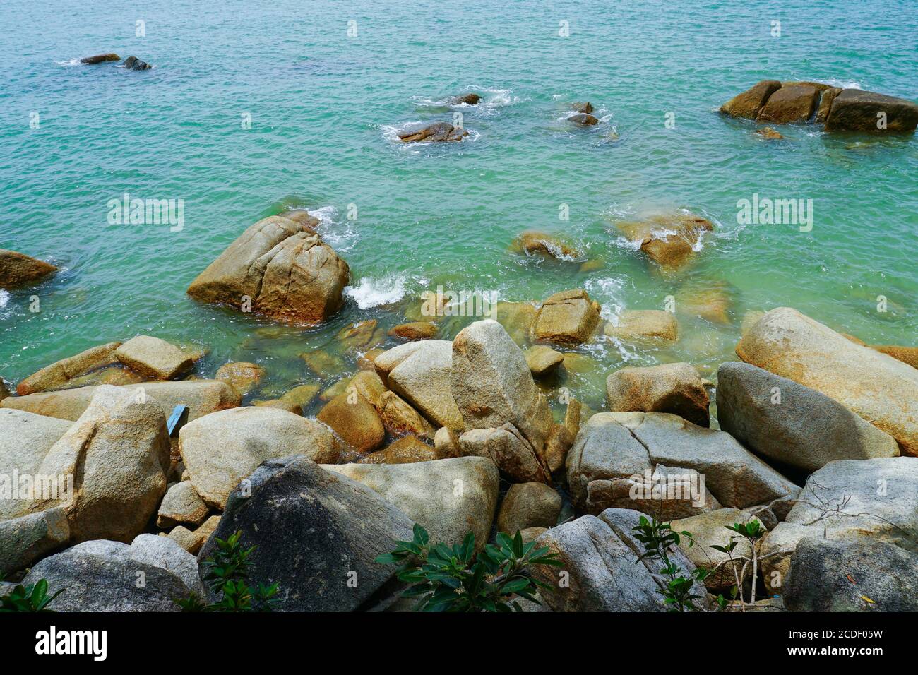 Spiaggia tropicale e cielo blu sfondo una spiaggia rocciosa paesaggio durante il giorno d'estate, bello turchese colore acqua di mare, vacanza di viaggio Foto Stock