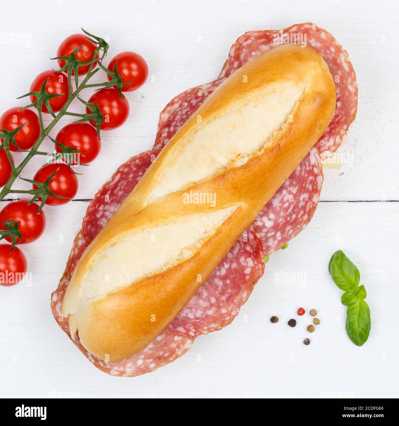 Baguette a sandwich con quadratino di salame dall'alto in legno legno da tavola Foto Stock