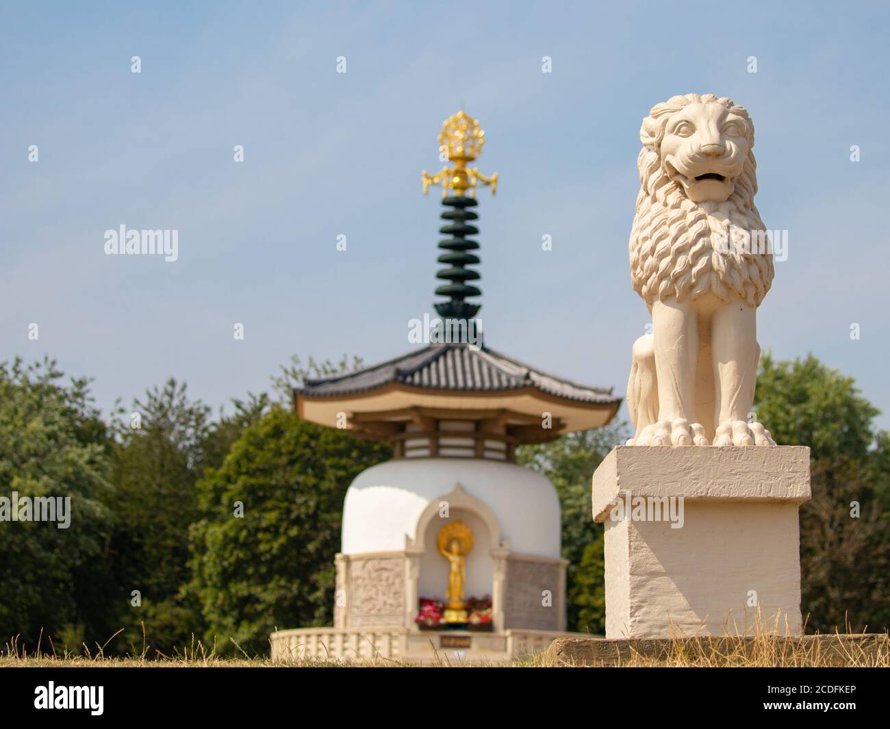 Una statua di leone che custodisce la Pagoda della Pace sul lago Willen Foto Stock