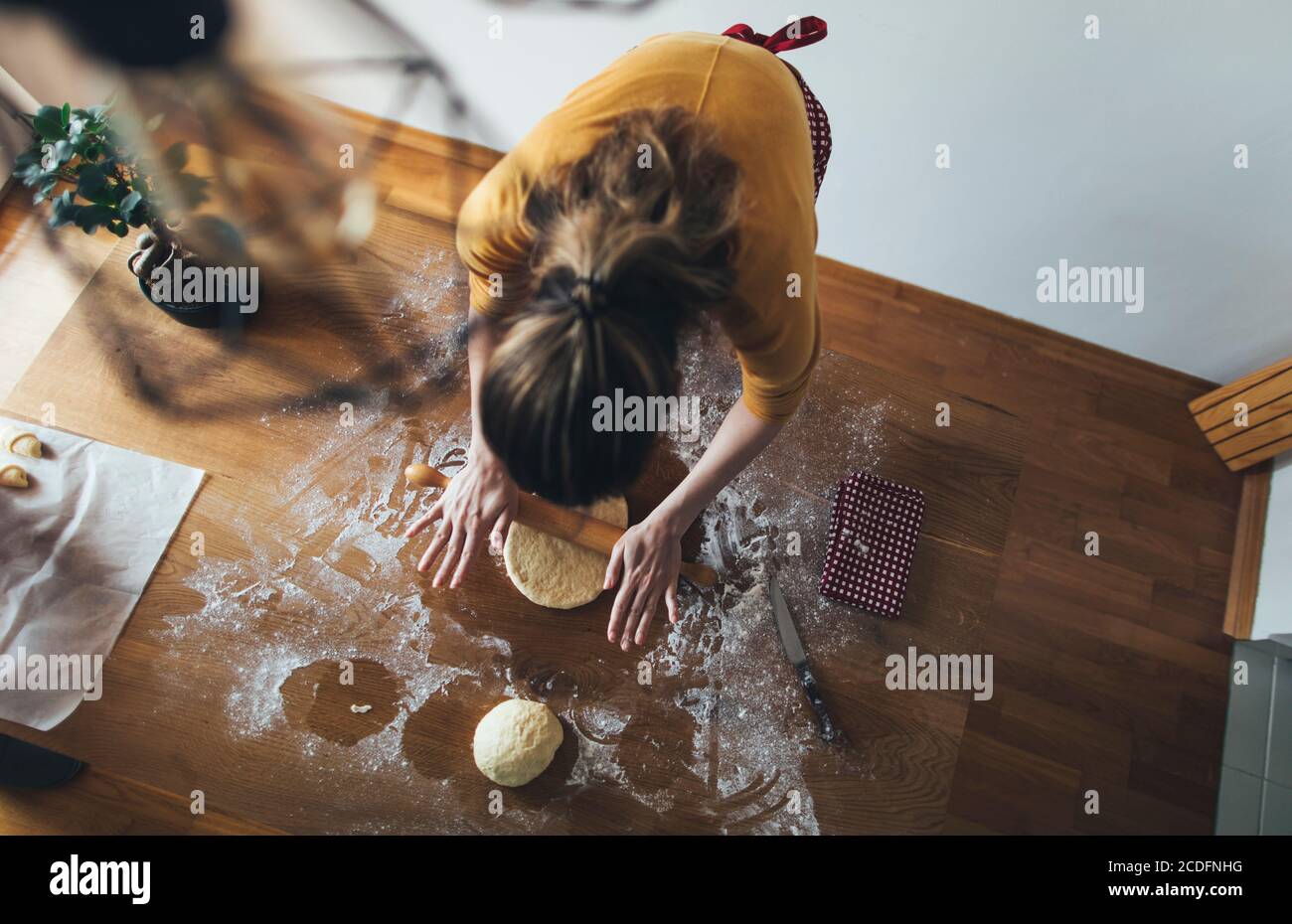Vista ad alto angolo della pasta per pane da donna in cucina tabella Foto Stock