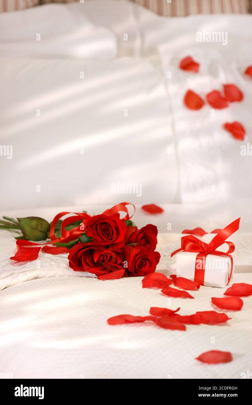 Rose rosse su un letto Foto stock - Alamy