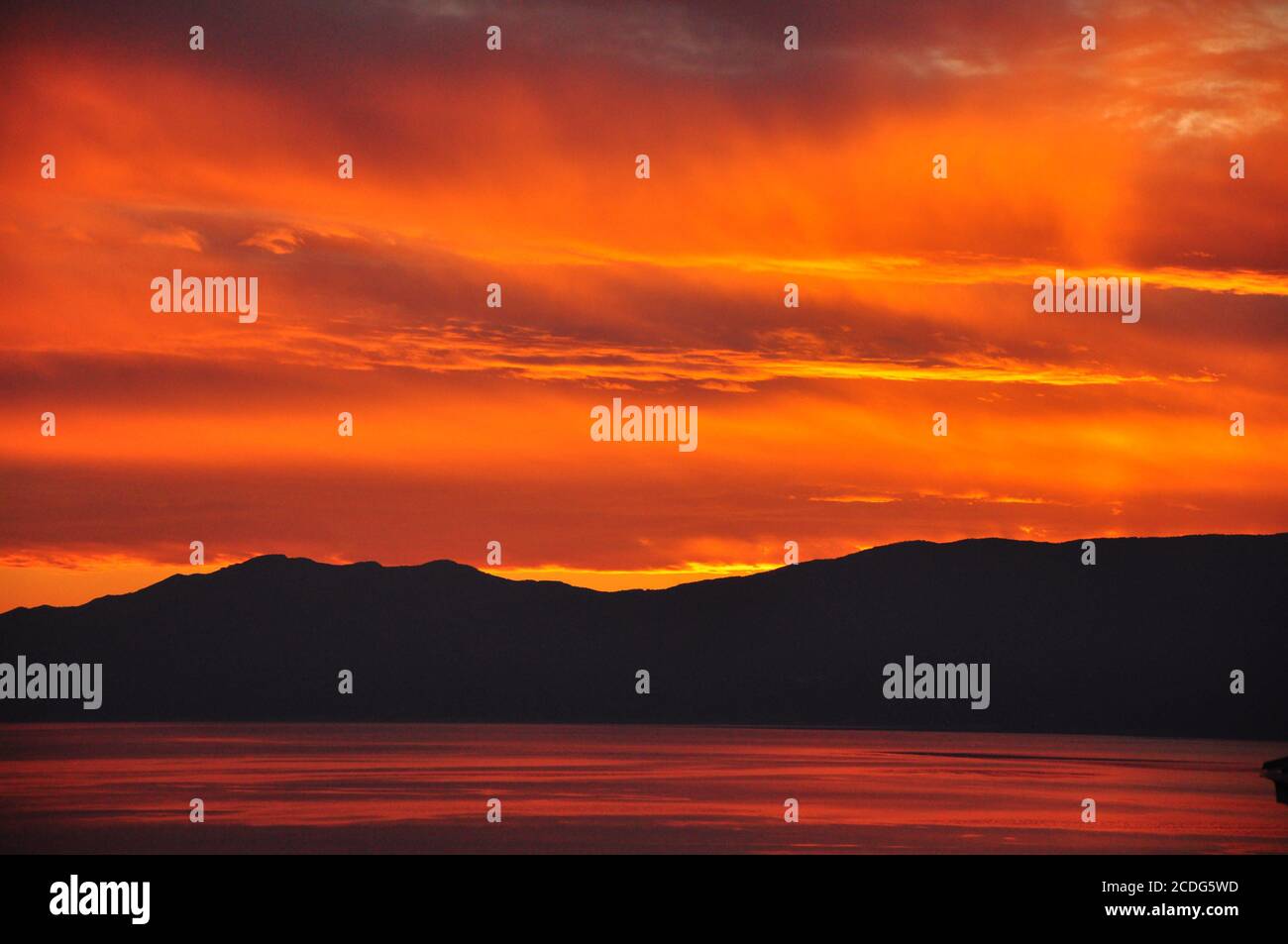 Tramonto di un sole rosso luminoso e di un cielo rosso scuro. Foto Stock