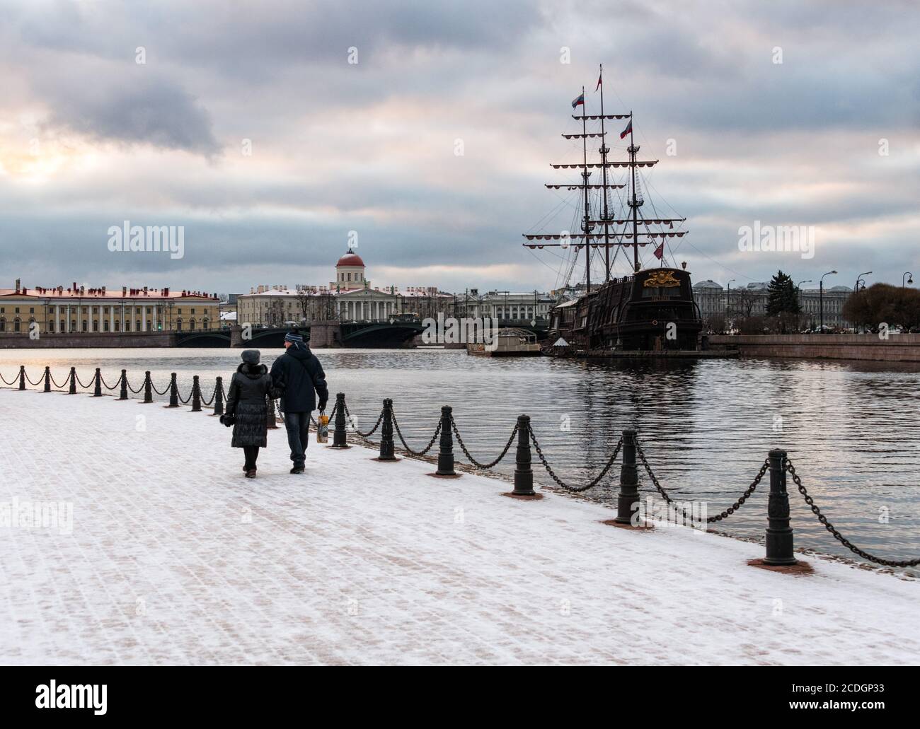 Una coppia che cammina lungo il fiume Neva in inverno, con il Vasilyevsky Ostrov sullo sfondo, San Pietroburgo, Russia Foto Stock