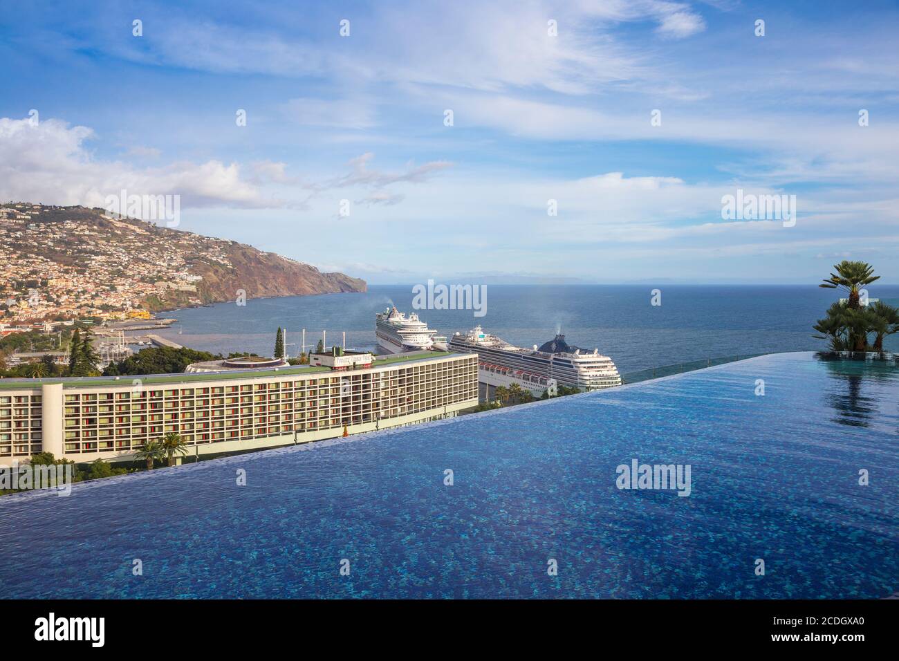 Portogallo, Madeira, Funchal, Vista dalla piscina infinity sul tetto del nuovo Royal Savoy Hotel che guarda verso il Pestana Casino Hotel e il terminal delle navi da crociera Foto Stock