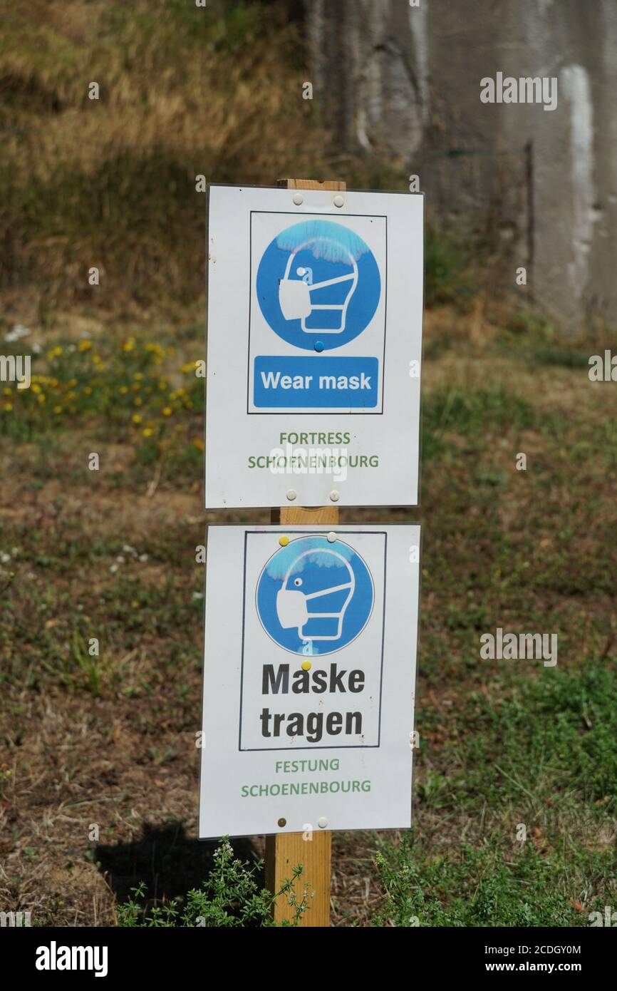 Obbligo di indossare maschera facciale su due cartelli in inglese e tedesco per i visitatori stranieri della Fortezza di Schoenenbourg sulla linea Maginot in Francia. Foto Stock