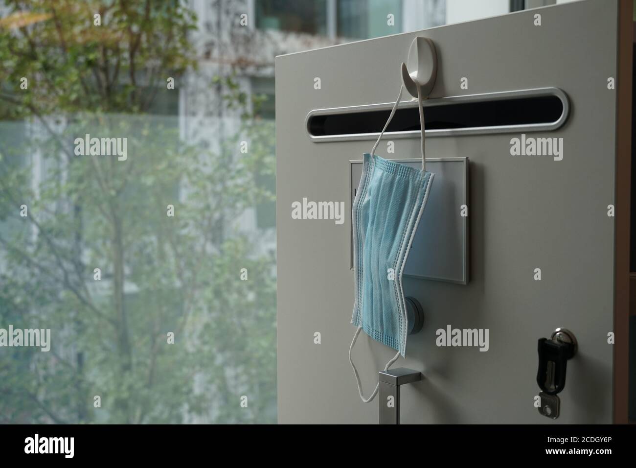 Una maschera facciale che consegna un cassetto in un ufficio in un edificio aziendale. Nuova normalità nello spazio di lavoro, protezione dal coronavirus e dalla covid-19. Nuovo normale, Foto Stock