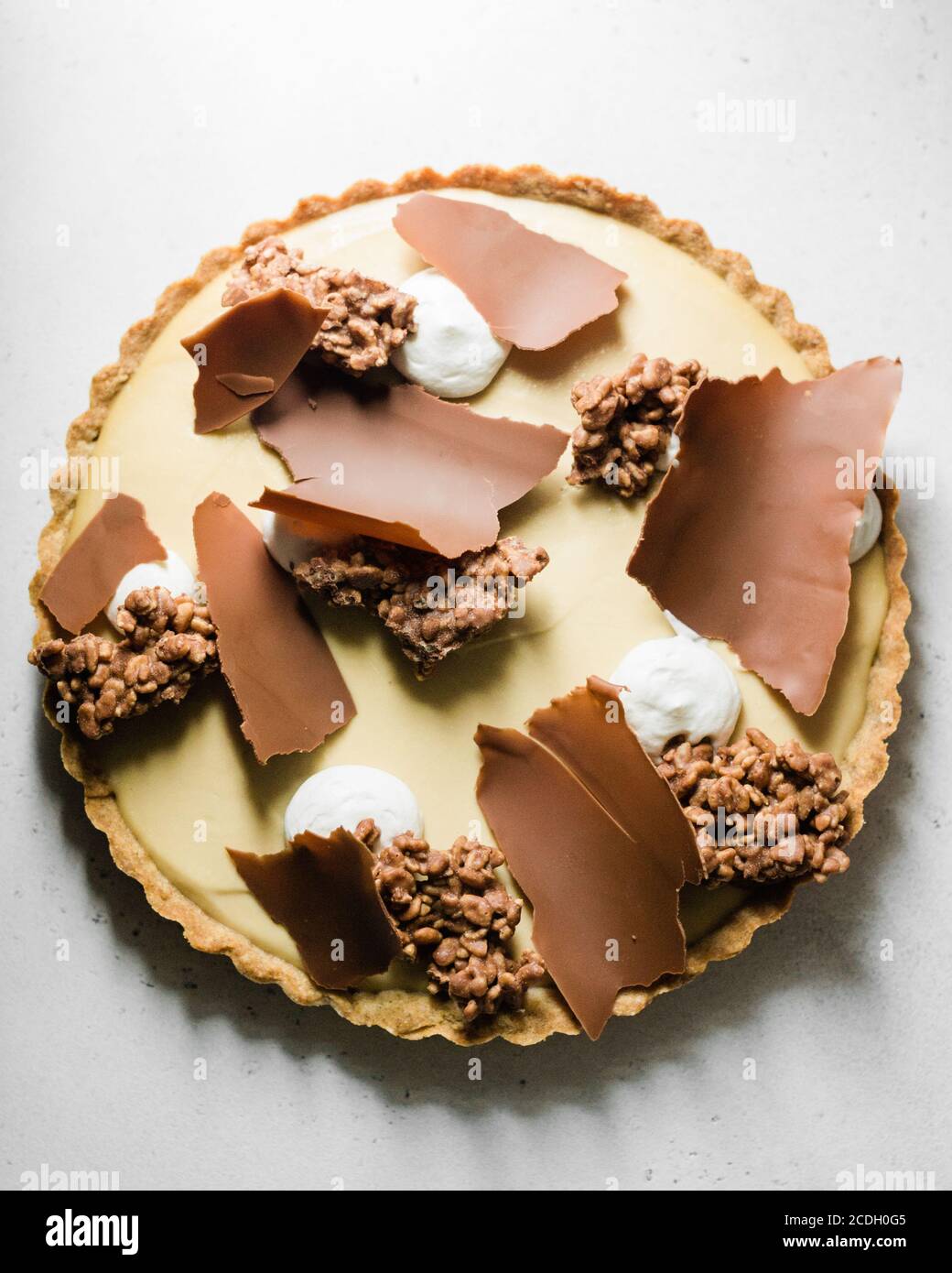 Torta al cioccolato con ricci al cioccolato e panna montata su bianco Tabella Foto Stock