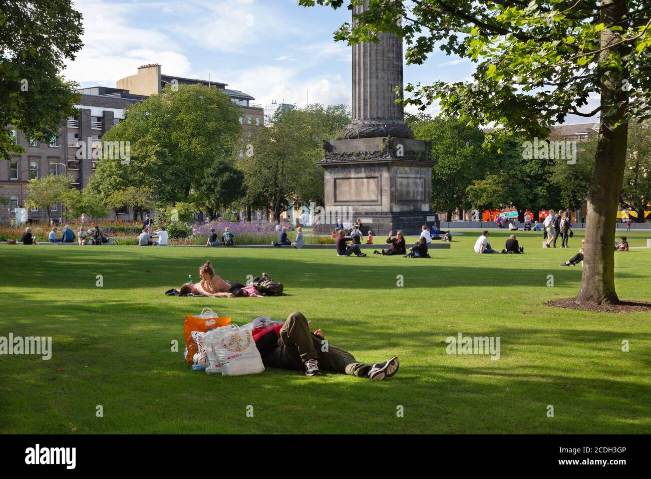 Persone che siedono sull'erba in estate St Andrew Square Edimburgo nuova città, Edimburgo Scozia Regno Unito Foto Stock