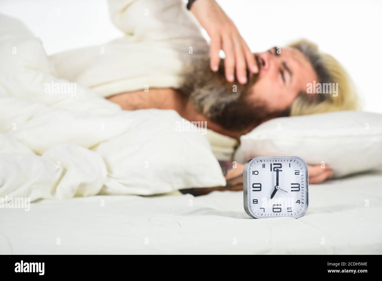 Ora di check-up. Sveglia digitale in camera da letto. È ora di svegliarsi.  L'uomo esausto è risvegliato dalla sveglia in camera da letto. Uomo maturo  sul letto spegnimento orologio. Uomo maturo disattivare