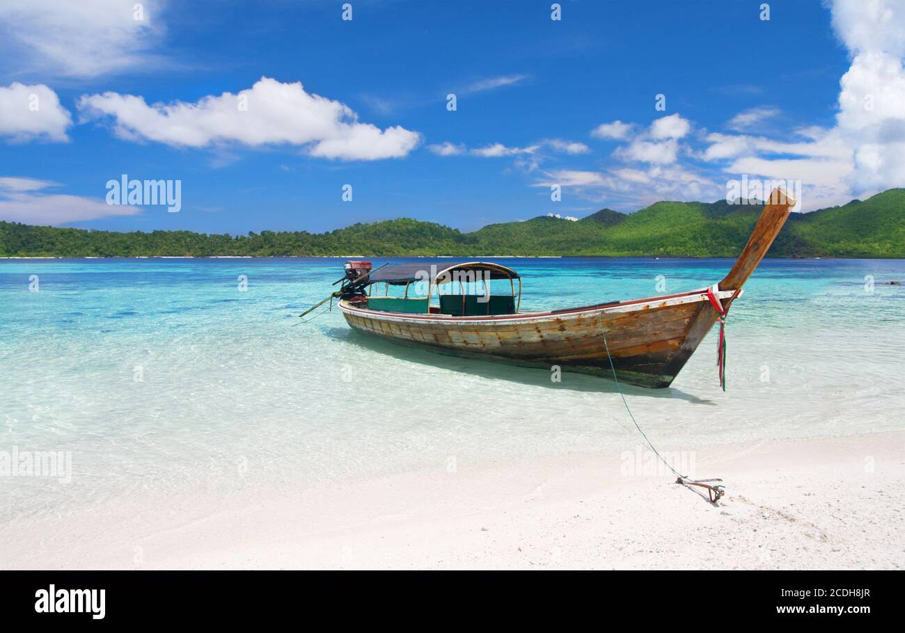 Longtail boat nella bellissima laguna vicino alla spiaggia di sabbia bianca Foto Stock