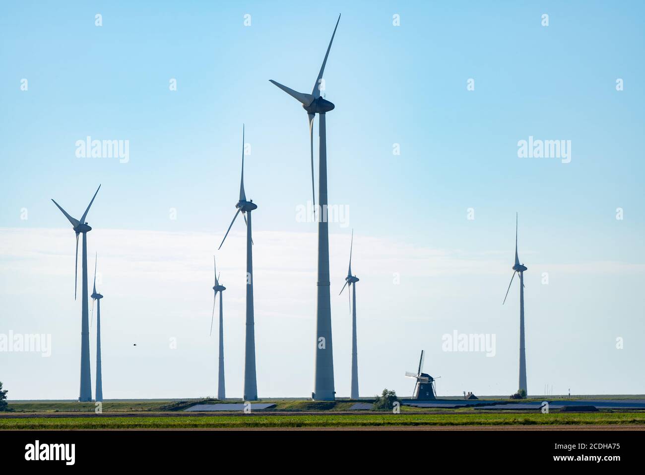 Vecchio mulino a vento in combinazione con nuove turbine a vento che generano pulito energia Foto Stock