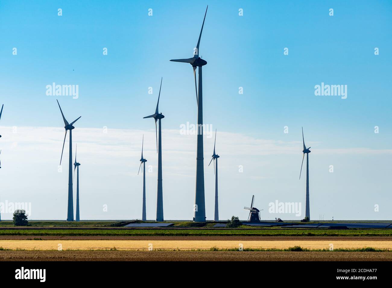 Vecchio mulino a vento in combinazione con nuove turbine a vento che generano pulito energia Foto Stock