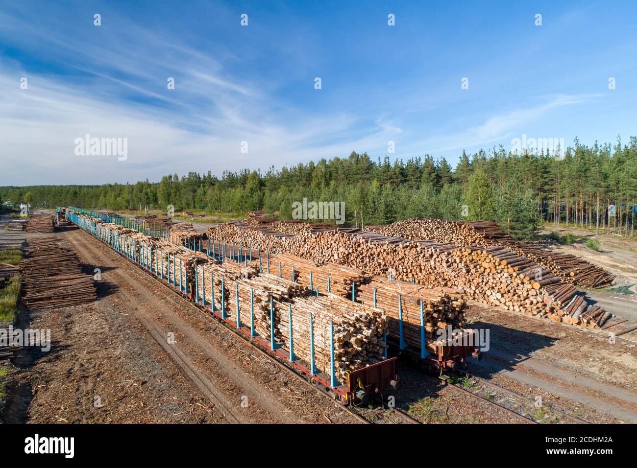 Vista aerea di un cantiere ferroviario con pali di tronchi e vagoni ferroviari caricati con legname per il trasporto a Estate, Finlandia Foto Stock