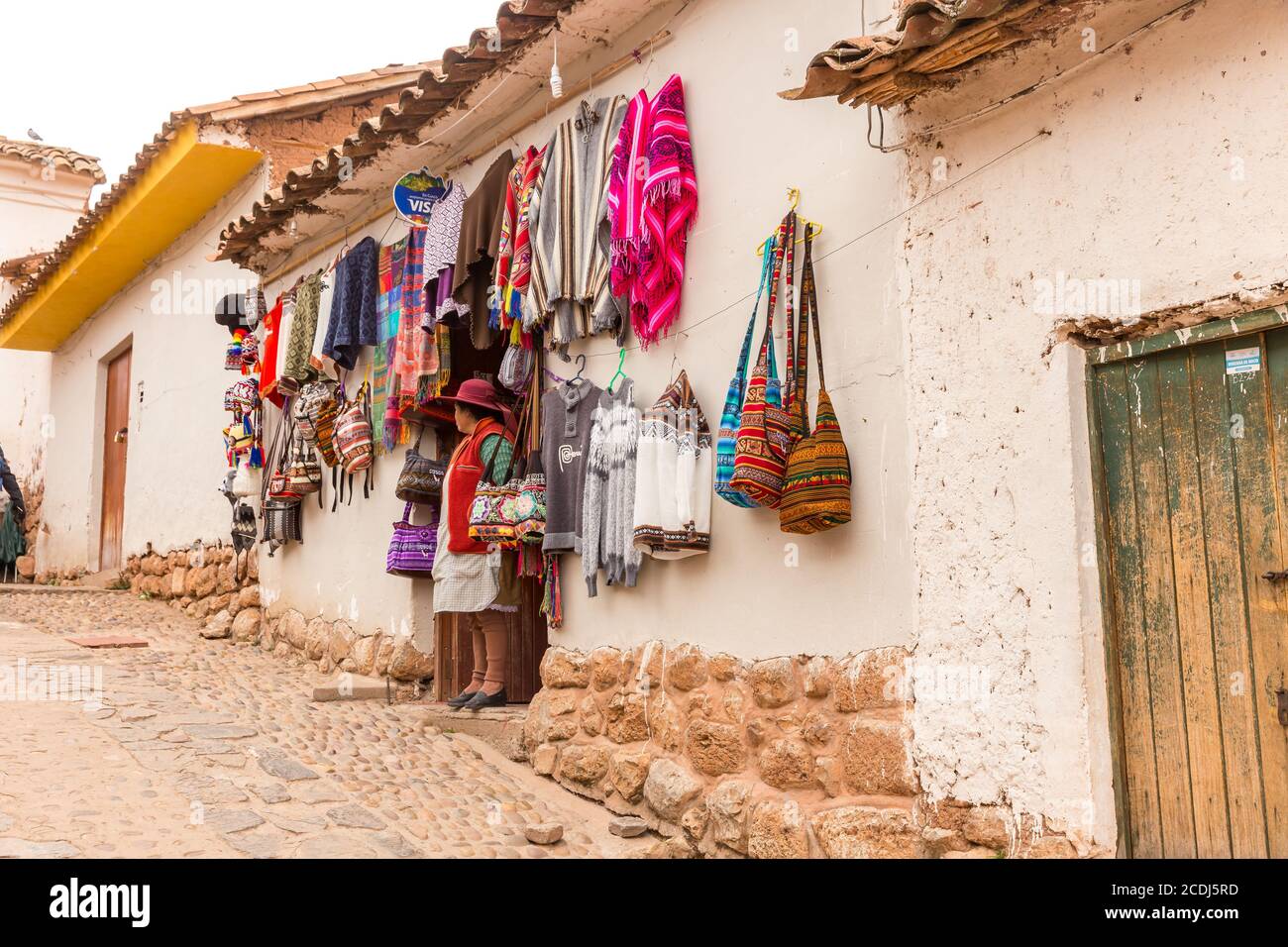 Chinchero, Perù - 05 ottobre 2018: Donna autoctona in un negozio con prodotti tessili alpaca fatti a mano e souvenir Foto Stock