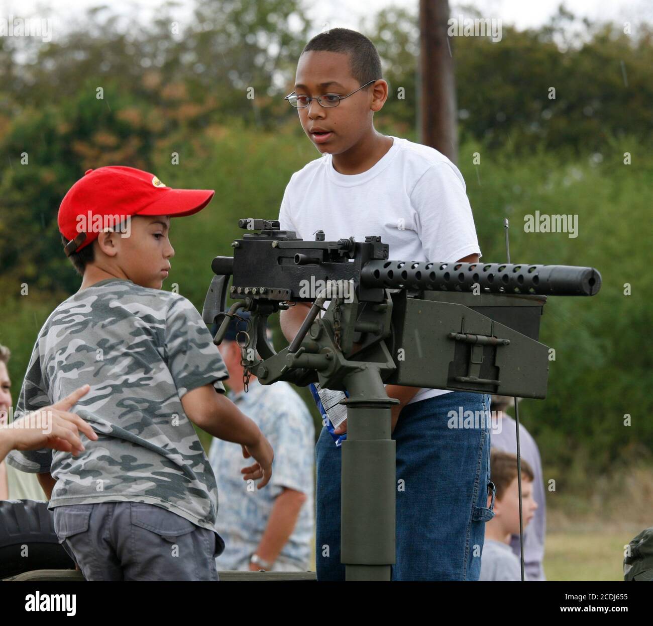 Austin, TX 11 novembre 2007: I bambini guardano a una mitragliatrice di calibro 30 durante le cerimonie del Veteran's Day a Camp Mabry, il quartier generale della Guardia Nazionale del Texas. ©Bob Daemmrich Foto Stock