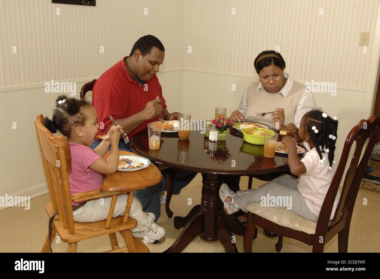 Pine Bluff, AR 16 ottobre 2006: Famiglia afroamericana con bambini piccoli che hanno cena da take-out di cibo messicano a casa. ©Bob Daemmrich Foto Stock