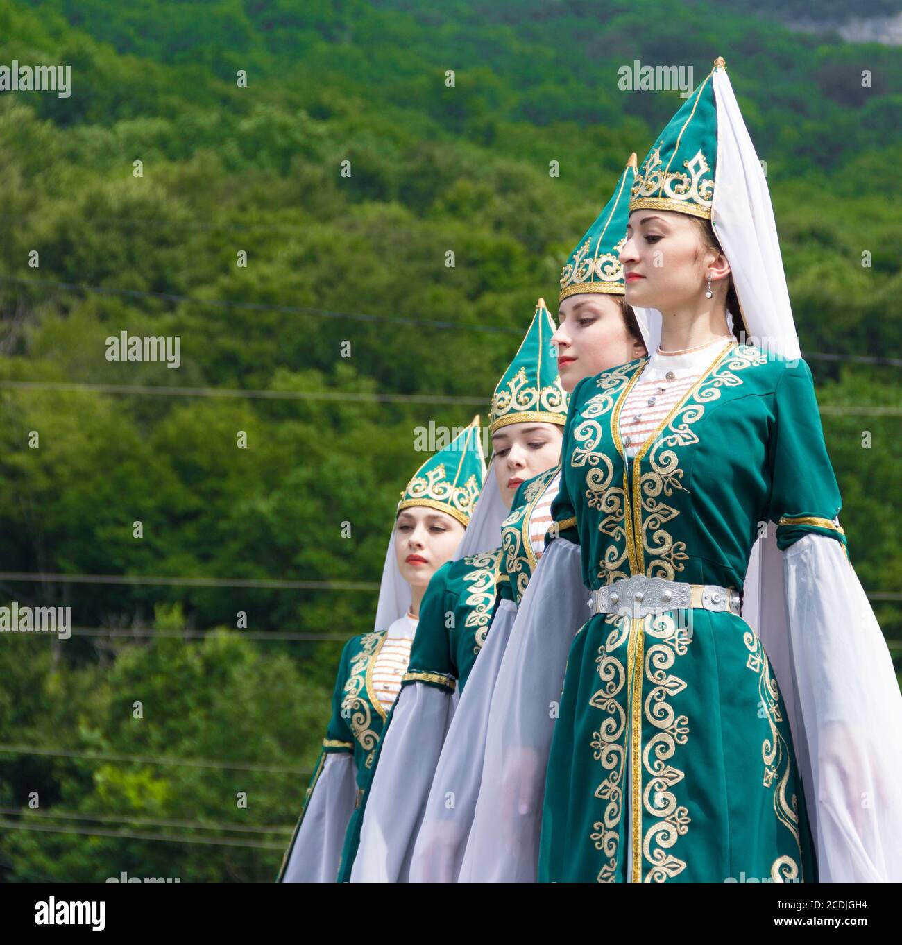 Adygea, RUSSIA - LUGLIO 25 2015: Giovani ragazze in Adyghe costumi nazionali danzare la danza tradizionale in un ethnosurge nelle colline del Caucaso in UN Foto Stock