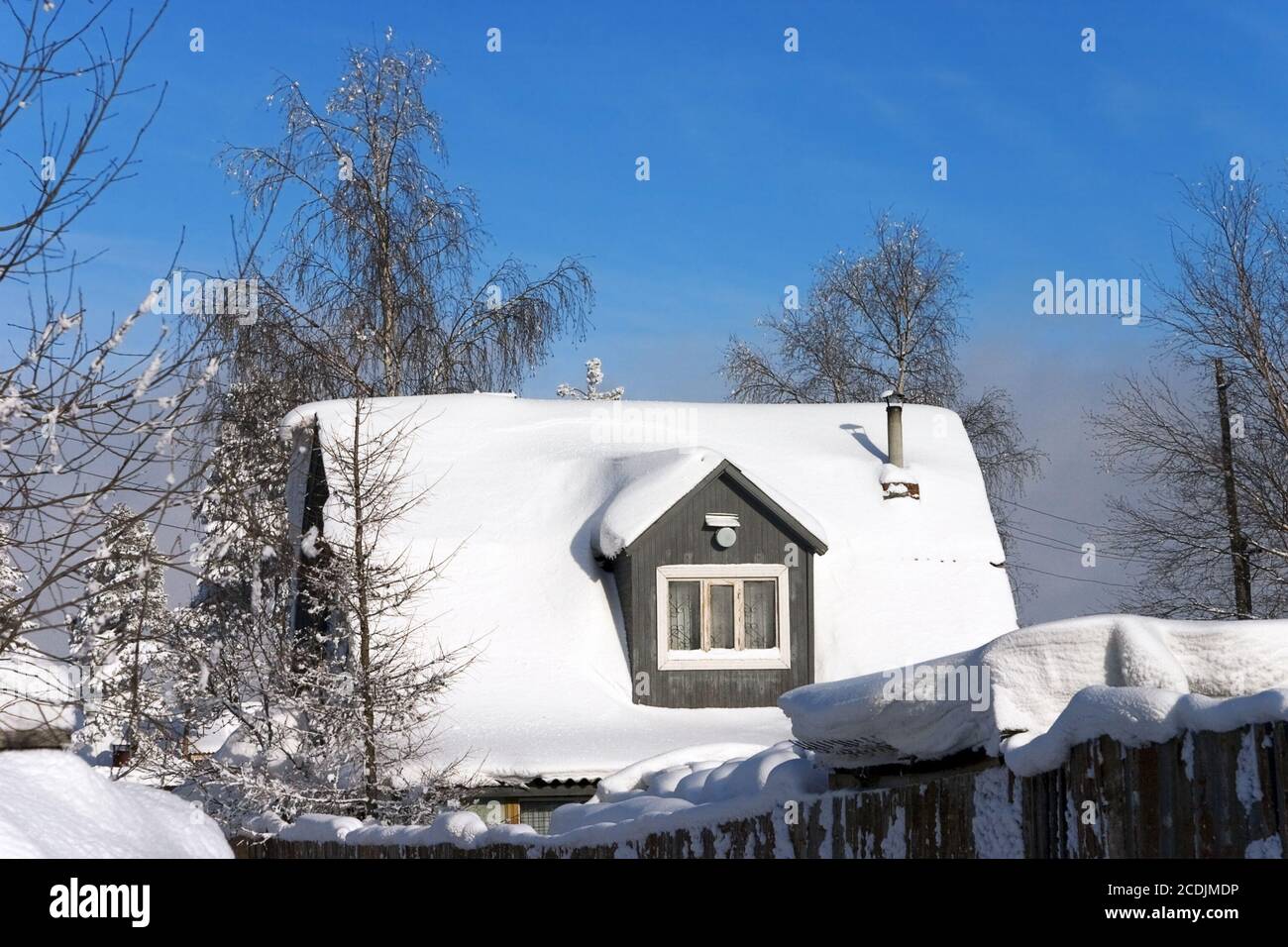 tetto innevato di una casa di villaggio Foto Stock