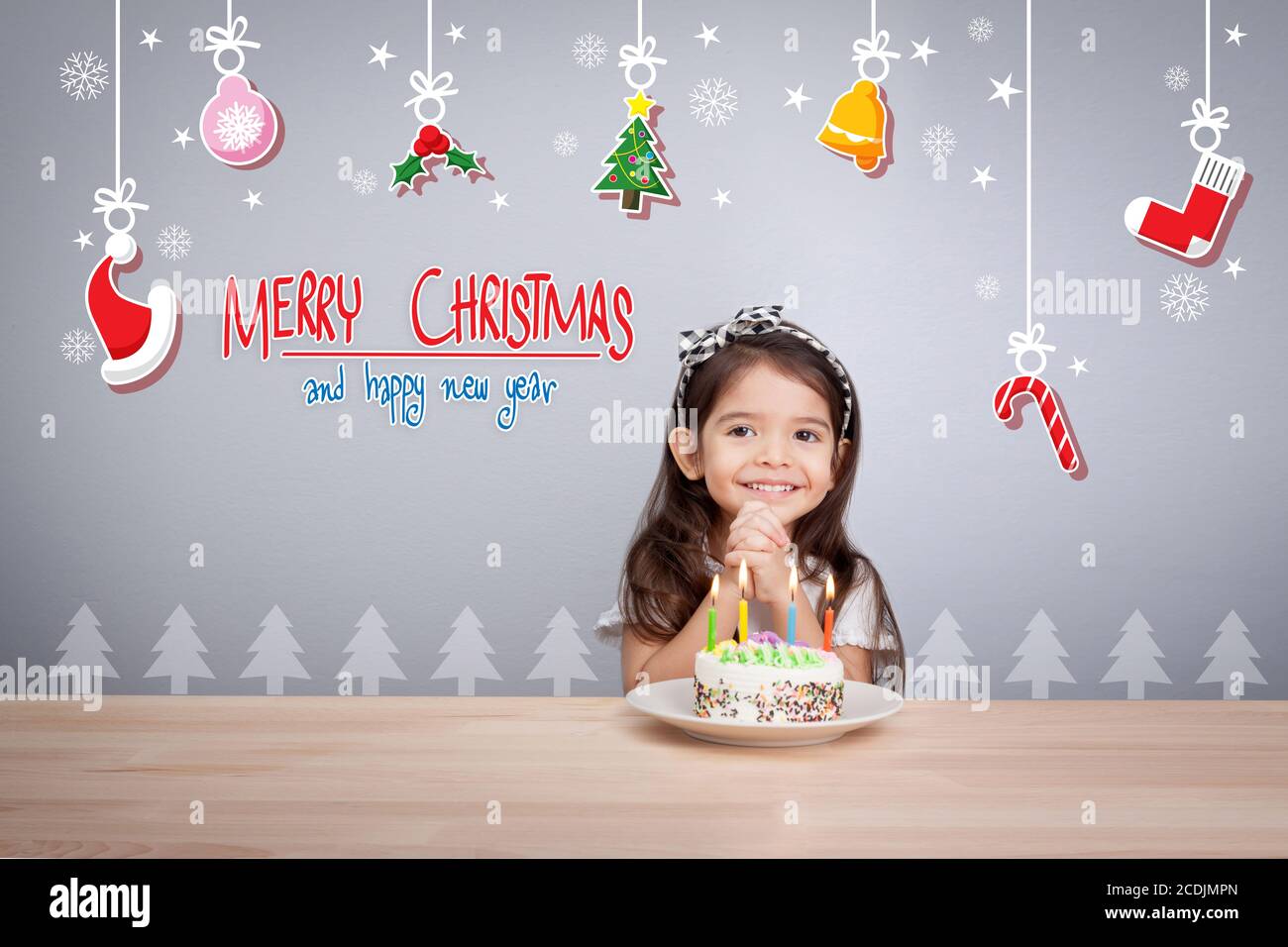 i bambini fanno un desiderio alla festa di nuovo anno con la torta e candela Foto Stock