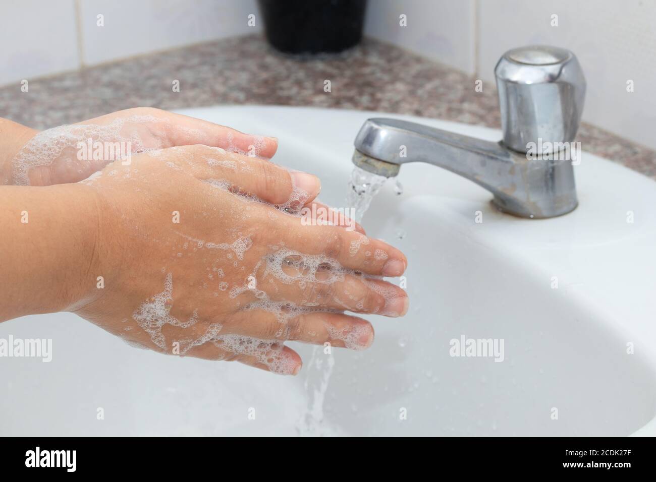 Concetto di igiene per la pulizia delle mani e delle mani. Un uomo lava le mani con sapone e acqua nel bacino. Foto Stock