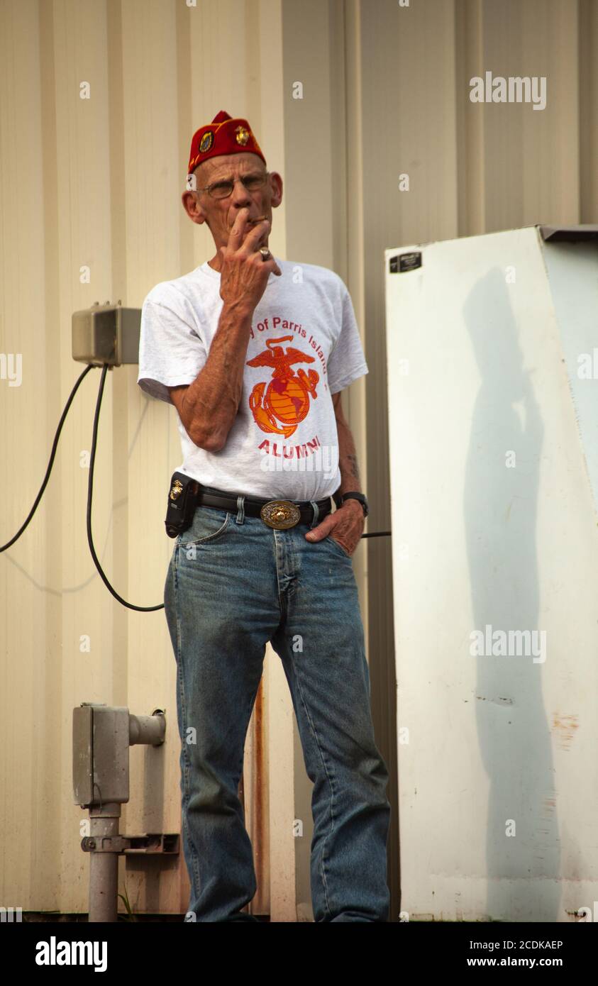 L'uomo vestito da marina fuma all'aperto durante la fiera di Goshen. Foto Stock