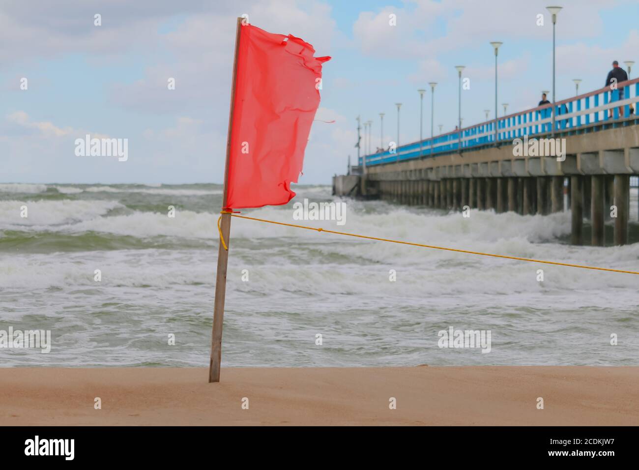 Segnale di avvertimento di una bandiera rossa su una bella spiaggia. È vietato nuotare Foto Stock
