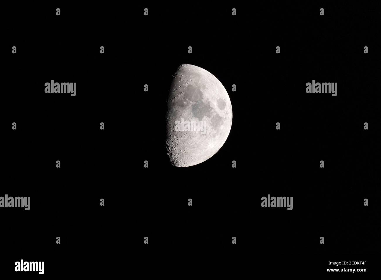 Mezzaluna cerante nel cielo notturno, con la linea di terminazione che mostra crateri d'impatto e ombre Foto Stock