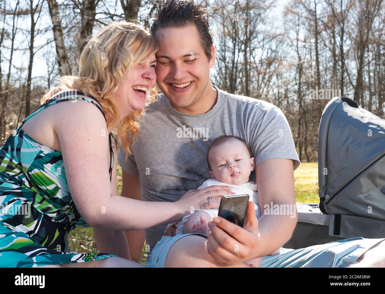La giovane famiglia sorride mentre prende un selfie Foto Stock