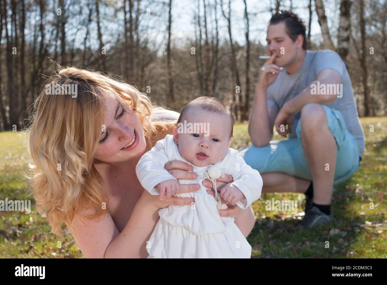 Padre che fuma una sigaretta mentre la sua famiglia sta aspettando lui Foto Stock