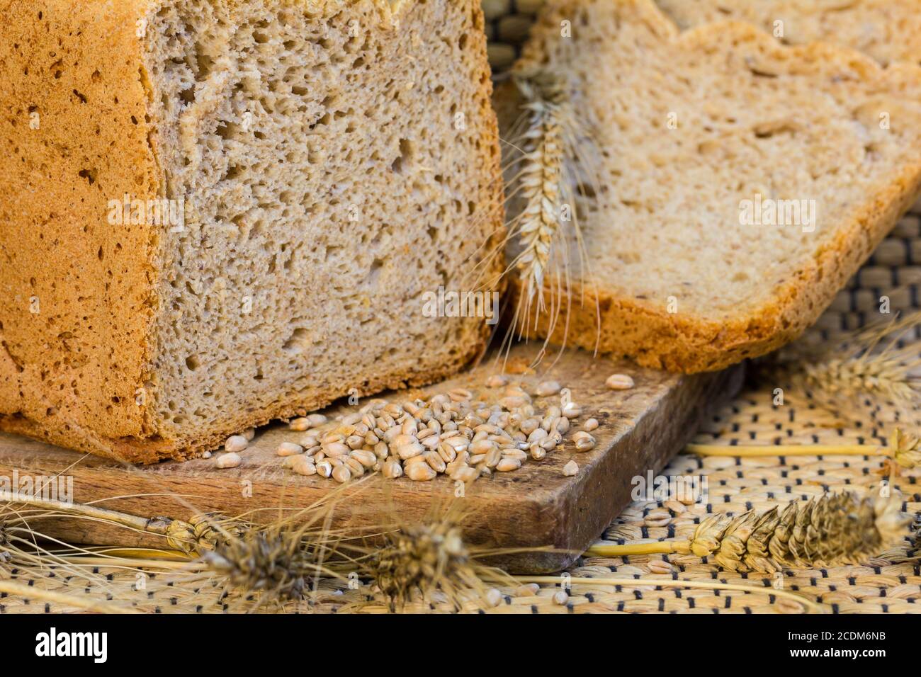 Il pane fatto in casa su una scena rustica con grano Foto Stock