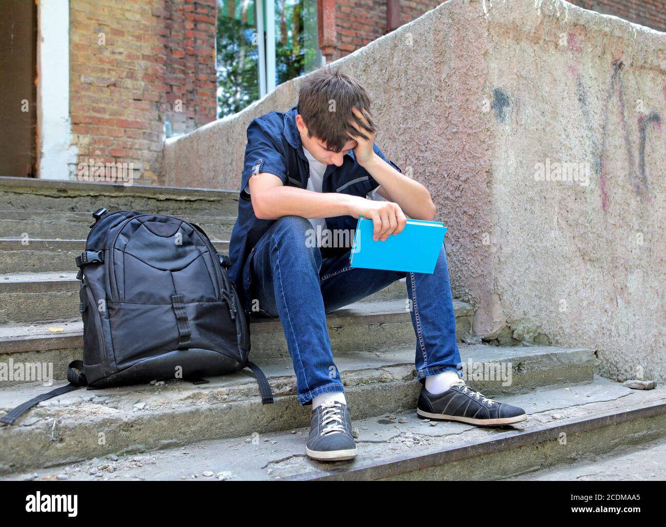 Triste studente con il libro Foto Stock
