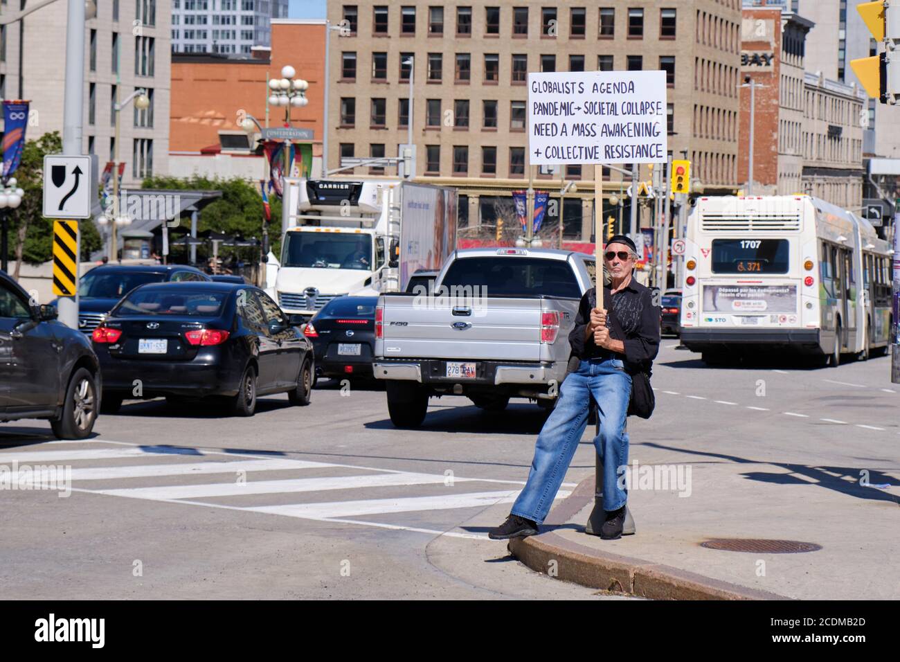Ottawa, Canada. Agosto 2020. Il protetore della cospirazione sul lato della strada con il segno che dichiara la pandemia del Covid 19 è una frode Foto Stock