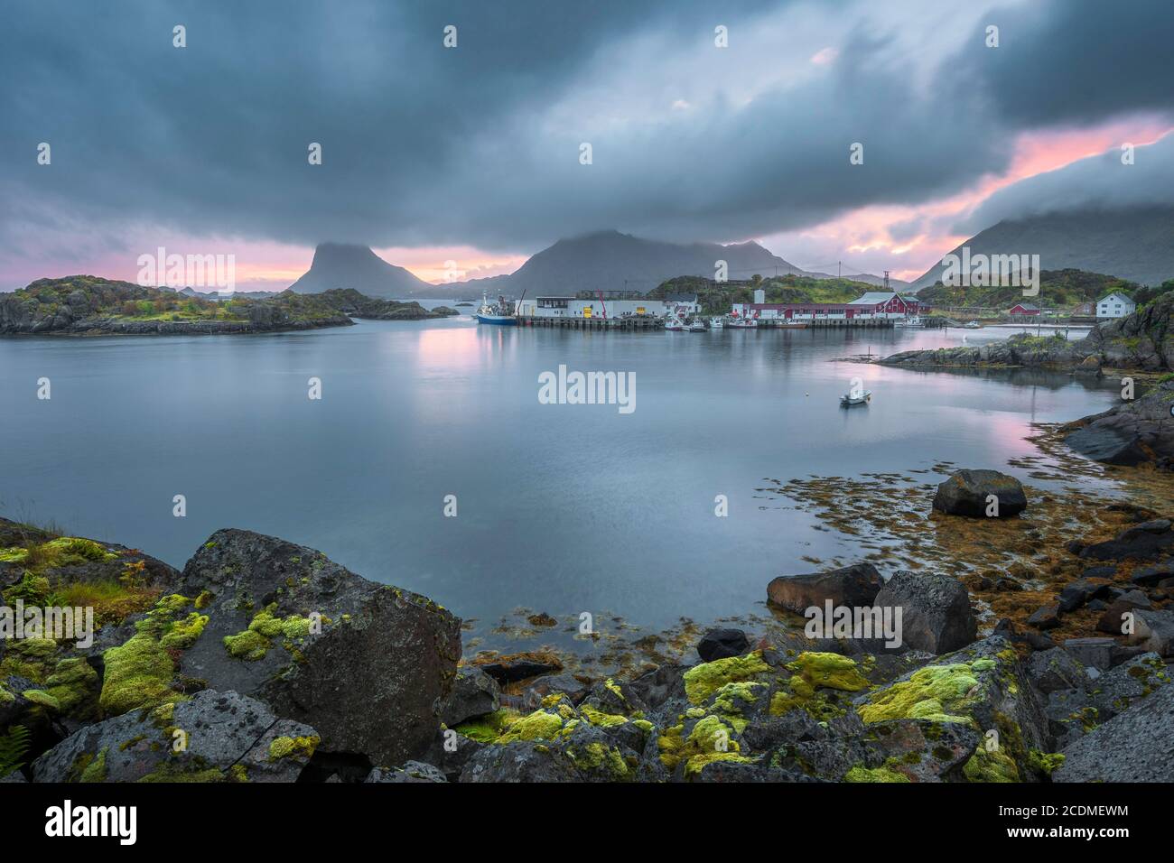 Porto dell'industria della pesca in un bacino di fiordi riparato, dietro Lofotenberge, Lofoten, Nordland, Norvegia Foto Stock