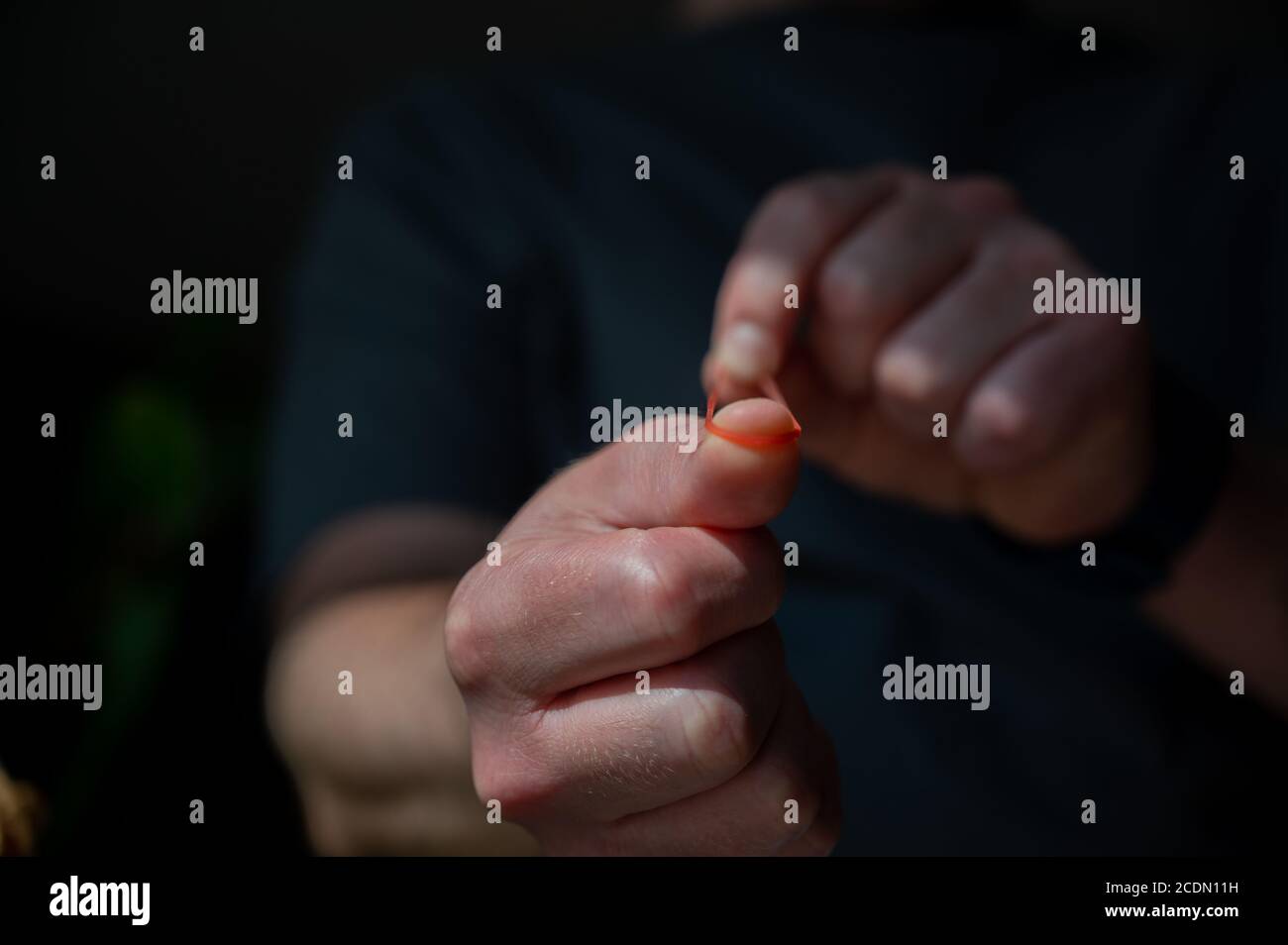 Sparare una fascia di gomma tirando un materiale elastico e. lasciarsi andare Foto Stock