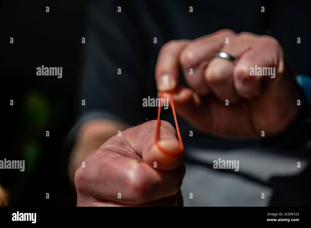 Sparare una fascia di gomma tirando un materiale elastico e. lasciarsi andare Foto Stock