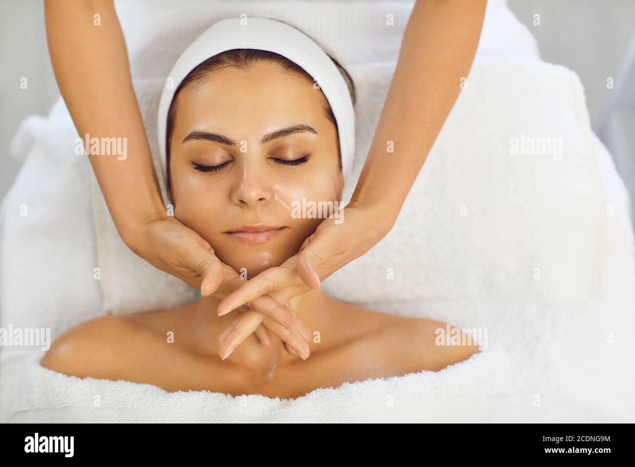Massaggio viso. L'estetista effettua un massaggio viso anti-invecchiamento con le mani in una clinica di cosmetologia Foto Stock