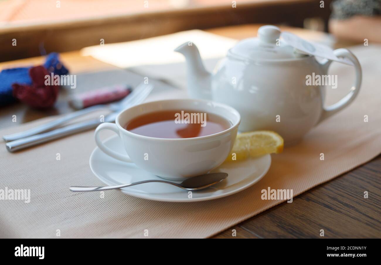 Tazza di tè con limone e teiera Foto Stock