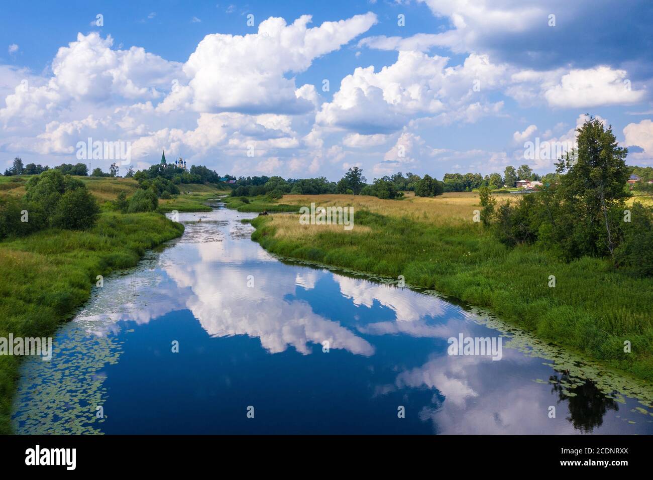 Paesaggio con belle nuvole di cumuli che si riflettono nel fiume Teza, regione Ivanovo in una giornata estiva. Foto Stock