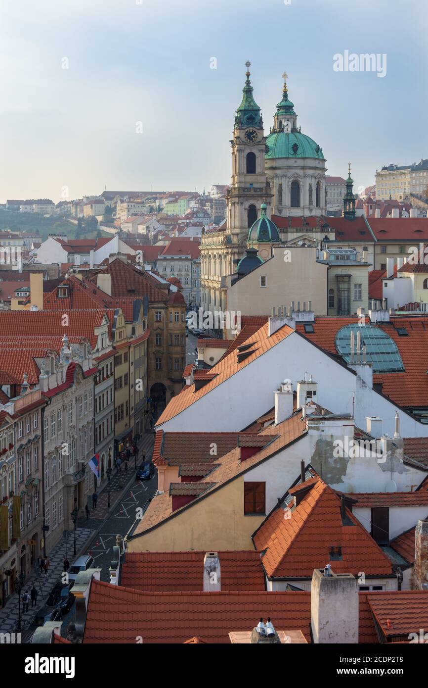 La chiesa di San Nicola e il castello sopra le cime del tetto di Mala Strana, Praga, Repubblica Ceca Foto Stock