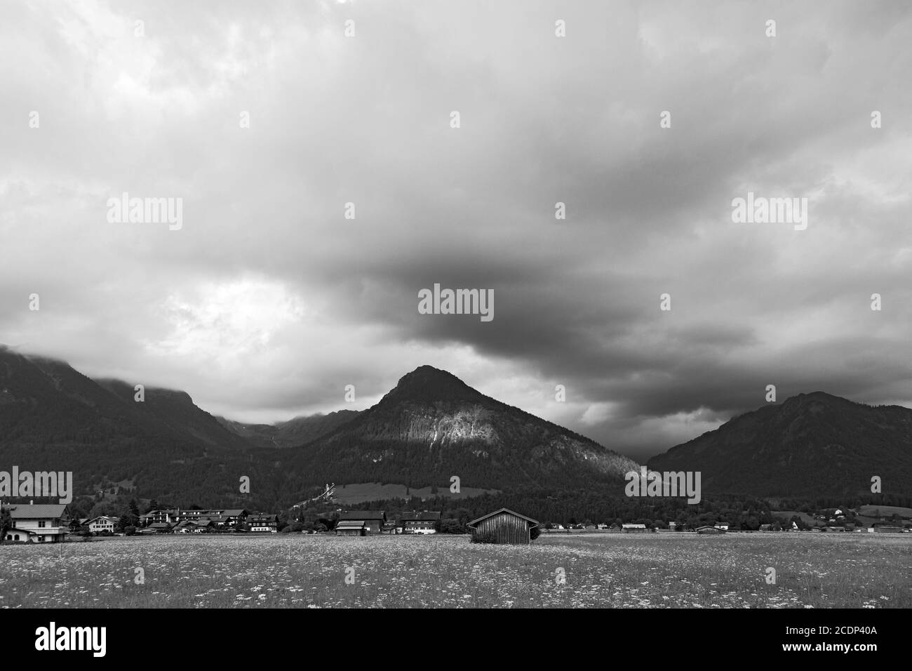 Oberstdorf, Scheune, Häuser, Sprungschanze, Berge, tiefliegende Wolken Foto Stock