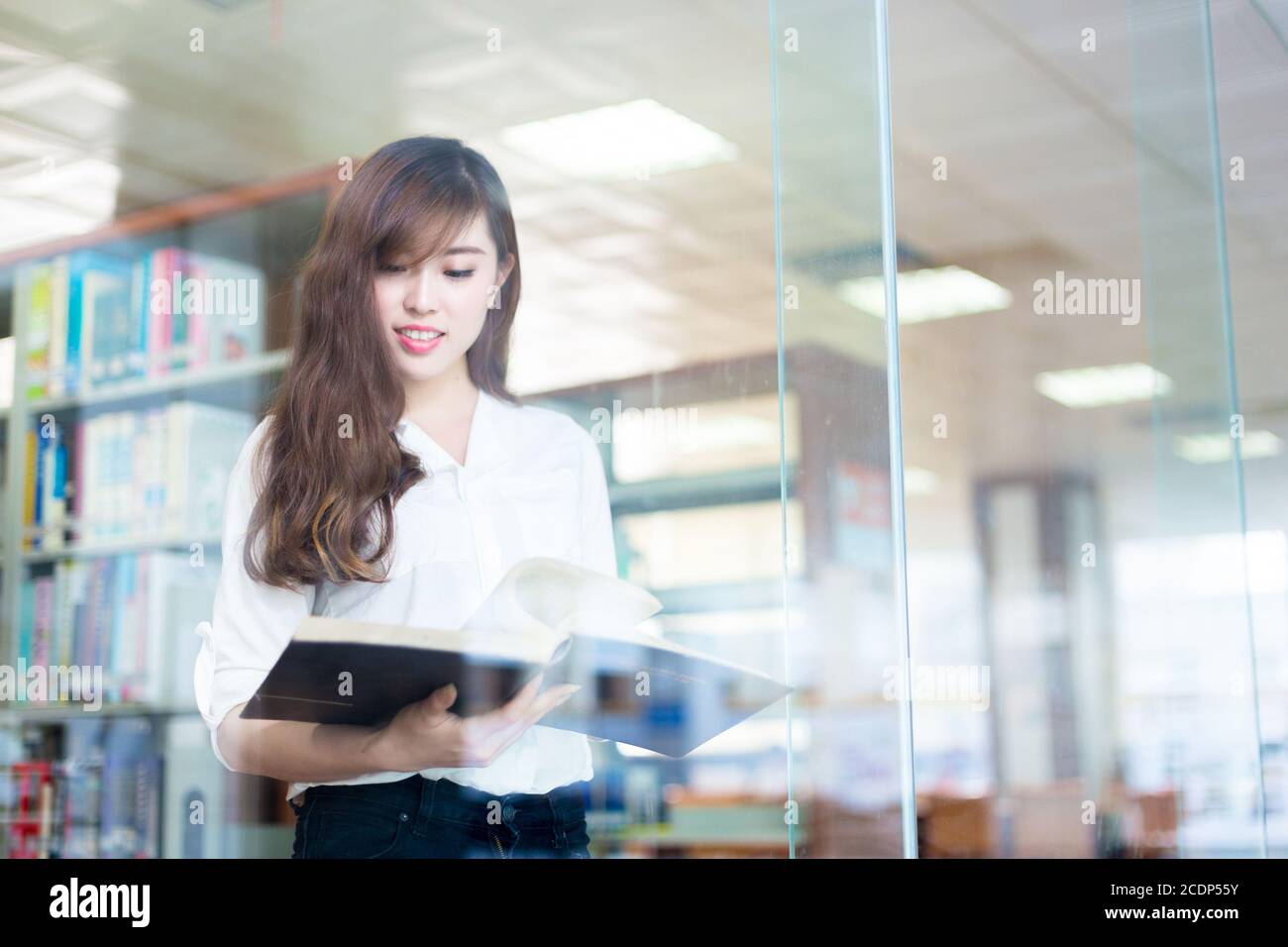 giovane bella studentessa asiatica in biblioteca Foto Stock