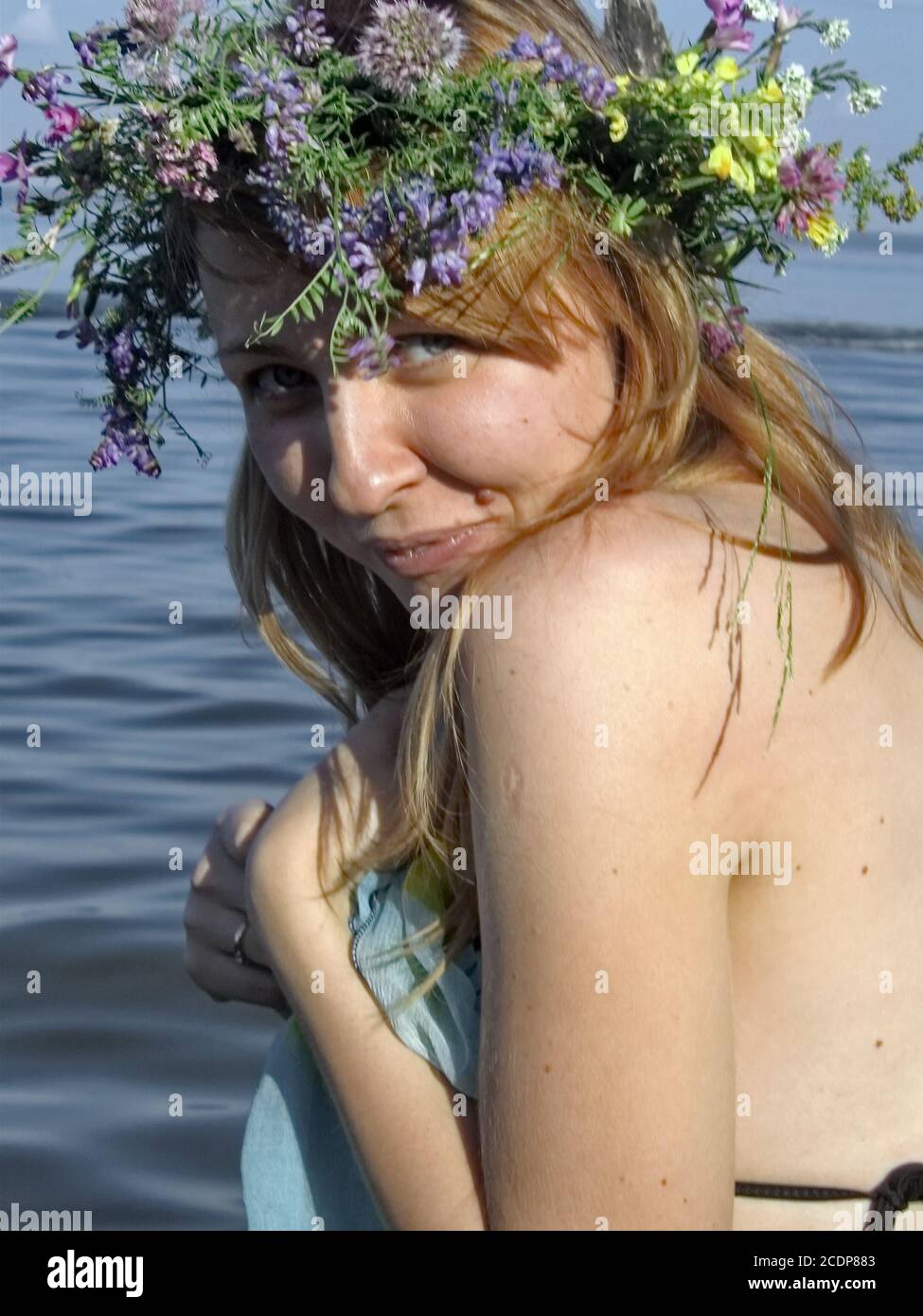 Ragazza incinta in estate vicino al mare con la corona testa Foto Stock